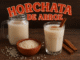 Vasos con horchata de arroz, canela en rama y tazón con granos sobre mesa de madera, con texto “Horchata de arroz”, ideal para recetas y bebidas tradicionales