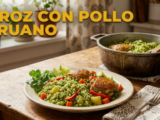 Plato de arroz con pollo peruano con arroz verde, verduras, pollo y limón, servido en mesa de cocina iluminada.